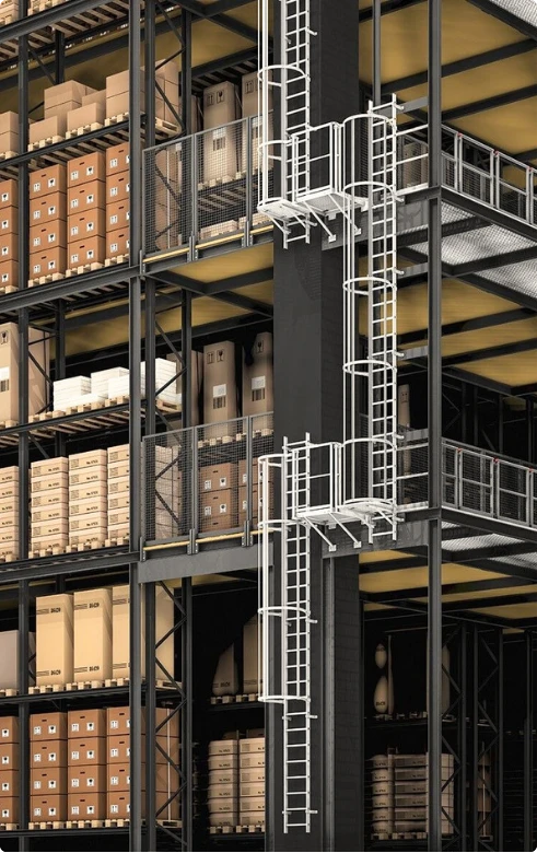 Escada marinheiro metálica com gaiola e patamares conectando níveis de mezanino em armazém com estantes e caixas.