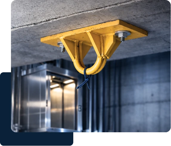 Ponto de ancoragem amarelo fixado no teto de concreto para linha de vida e trabalho em altura.