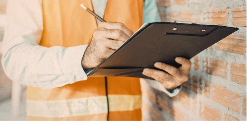Técnico com prancheta preenchendo checklist, representando dossiê e documentação para auditoria.