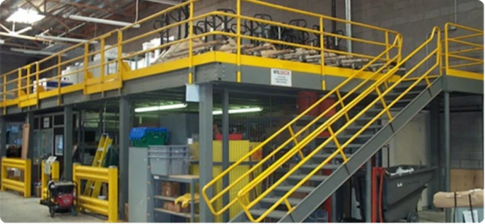 Mezanino industrial com guarda-corpo amarelo e escada metálica lateral para ampliação de área útil em galpão.